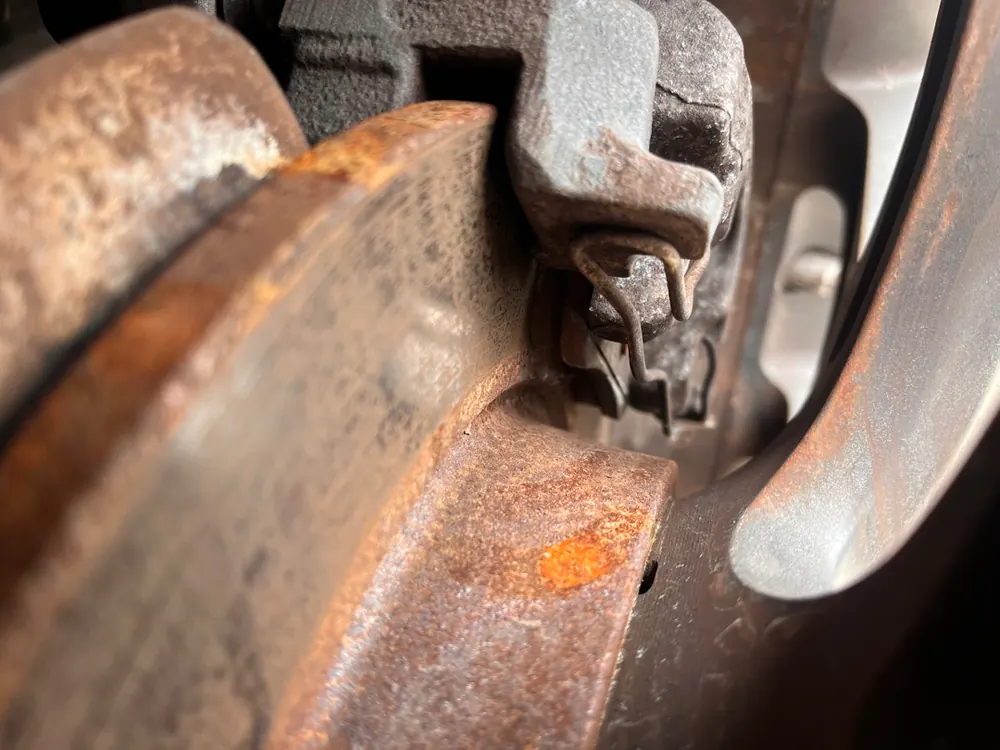 Worn and rusted brake rotor with the wheel removed